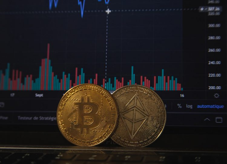 Featured image for bitcoin price decline story showing two bitcoins placed near a screen